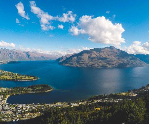 Aerial view of a town surrounded by mountains and a lake